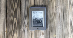 A photo of the Kindle version of New York 2140 against a wooden floor.