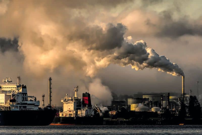 A photo of a port next to what appears to be a gas or coal power plant.